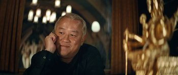 Movie still from “Infernal Affairs” (2002), directed by Alan Mak – An older man sitting at a table in a restaurant; Close Up shot, Low angle