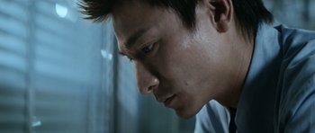 Movie still from “Infernal Affairs” (2002), directed by Alan Mak – A person looking down at his face; Close Up shot, Low angle