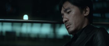 Movie still from “Infernal Affairs” (2002), directed by Alan Mak – A person sitting down with his eyes closed; Close Up shot, Low angle