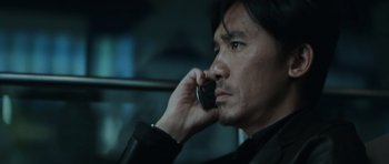 Movie still from “Infernal Affairs” (2002), directed by Alan Mak – A person talking on a cell phone; Close Up shot, Low angle