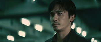 Movie still from “Infernal Affairs” (2002), directed by Alan Mak – A person wearing a black shirt; Close Up shot, Low angle