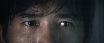 Movie still from “Infernal Affairs” (2002), directed by Alan Mak – A man's eyes with a dark background; Extreme Close Up shot, High angle
