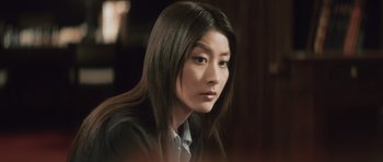 Movie still from “Infernal Affairs” (2002), directed by Alan Mak – A woman with long black hair sitting in a room; Close Up shot, Low angle