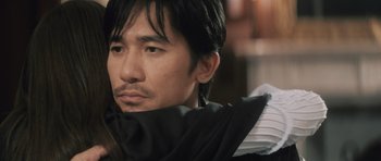 Movie still from “Infernal Affairs” (2002), directed by Alan Mak – A person wearing a jacket; Close Up shot, Over the shoulder angle