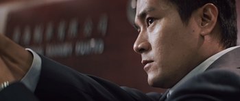 Movie still from “Infernal Affairs” (2002), directed by Alan Mak – A man's face looking into the distance; Close Up shot, Low angle