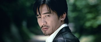 Movie still from “Infernal Affairs” (2002), directed by Alan Mak – A person wearing a jacket; Close Up shot, Low angle