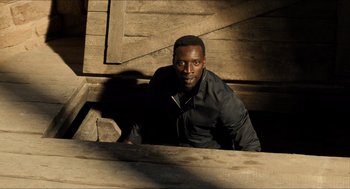 Movie still from “Inferno” (2016), directed by Ron Howard – A man sitting on top of a wooden bench; Medium shot, High angle