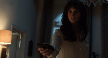 Movie still from “Inferno” (2016), directed by Ron Howard – A woman holding a remote in her hand; Close Up shot, Over the shoulder angle