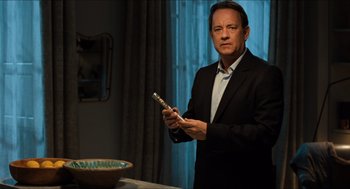 Movie still from “Inferno” (2016), directed by Ron Howard – A man in a black suit holding a cell phone; Medium shot, High angle