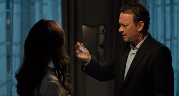 Movie still from “Inferno” (2016), directed by Ron Howard – A man in a black suit is holding something in his hand; Close Up shot, Over the shoulder angle