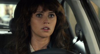 Movie still from “Inferno” (2016), directed by Ron Howard – A person sitting in a car looking at the camera; Close Up shot, Over the shoulder angle