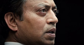 Movie still from “Inferno” (2016), directed by Ron Howard – A man's face with a black background; Close Up shot, Low angle