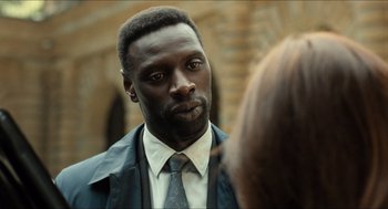 Movie still from “Inferno” (2016), directed by Ron Howard – A man wearing a suit and tie talking to a woman; Close Up shot, Over the shoulder angle