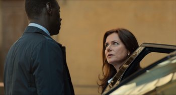 Movie still from “Inferno” (2016), directed by Ron Howard – A man and a woman standing next to each other in front of a car; Close Up shot, Over the shoulder angle