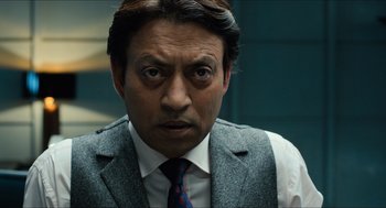 Movie still from “Inferno” (2016), directed by Ron Howard – A person wearing a suit and tie; Close Up shot, Over the shoulder angle