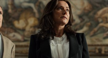 Movie still from “Inferno” (2016), directed by Ron Howard – A person wearing a suit and tie; Close Up shot, Low angle