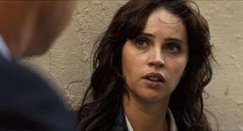 Movie still from “Inferno” (2016), directed by Ron Howard – A person with long brown hair; Close Up shot, Over the shoulder angle