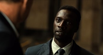 Movie still from “Inferno” (2016), directed by Ron Howard – A man wearing a suit and tie looking to his left; Close Up shot, Over the shoulder angle