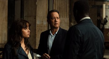 Movie still from “Inferno” (2016), directed by Ron Howard – Two men and a woman standing next to each other; Medium shot, Over the shoulder angle