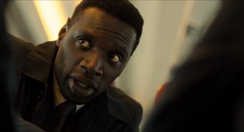 Movie still from “Inferno” (2016), directed by Ron Howard – A person wearing a suit and tie; Close Up shot, Over the shoulder angle