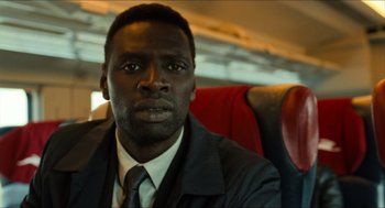 Movie still from “Inferno” (2016), directed by Ron Howard – A man sitting on a seat on a train; Close Up shot, Over the shoulder angle