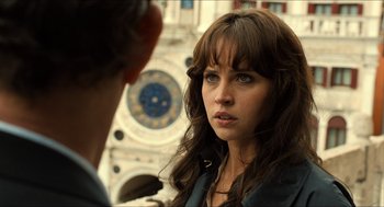 Movie still from “Inferno” (2016), directed by Ron Howard – A woman is looking at a man in front of a clock tower; Close Up shot, Over the shoulder angle