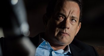 Movie still from “Inferno” (2016), directed by Ron Howard – A man in a blue shirt and a black jacket looking to his left; Close Up shot, Over the shoulder angle