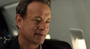Movie still from “Inferno” (2016), directed by Ron Howard – A person wearing a suit and tie; Close Up shot, Over the shoulder angle