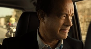 Movie still from “Inferno” (2016), directed by Ron Howard – A person in a car wearing a suit; Close Up shot, Over the shoulder angle