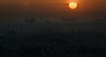 Movie still from “Inferno” (2016), directed by Ron Howard – The sun is setting over a city skyline; Extreme Wide shot, High angle