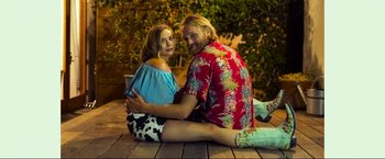Movie still from “Ingrid Goes West” (2017), directed by Matt Spicer – A man and a woman sitting on the ground together; Medium shot, Low angle