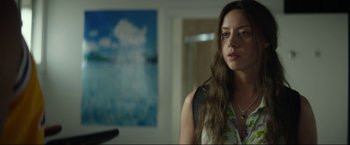 Movie still from “Ingrid Goes West” (2017), directed by Matt Spicer – A woman standing in front of a painting in a living room; Medium shot, Over the shoulder angle