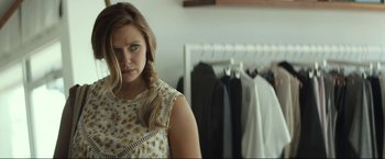 Movie still from “Ingrid Goes West” (2017), directed by Matt Spicer – A woman standing in front of a rack of clothes; Close Up shot, Over the shoulder angle