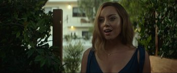 Movie still from “Ingrid Goes West” (2017), directed by Matt Spicer – A beautiful young woman standing in front of a building; Close Up shot, Over the shoulder angle