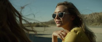 Movie still from “Ingrid Goes West” (2017), directed by Matt Spicer – A woman wearing sunglasses and a yellow shirt; Close Up shot, Over the shoulder angle