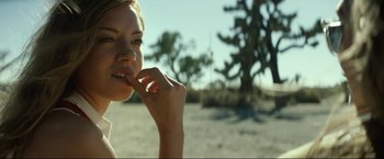 Movie still from “Ingrid Goes West” (2017), directed by Matt Spicer – A young woman eating something outside in the desert; Close Up shot, Over the shoulder angle