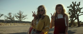 Movie still from “Ingrid Goes West” (2017), directed by Matt Spicer – Two young women standing next to each other on a beach; Medium shot, Low angle