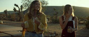 Movie still from “Ingrid Goes West” (2017), directed by Matt Spicer – A woman standing next to another woman holding a drink; Medium shot, Over the shoulder angle