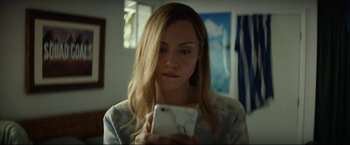 Movie still from “Ingrid Goes West” (2017), directed by Matt Spicer – A woman looking at her cell phone while sitting in a room; Close Up shot, Low angle