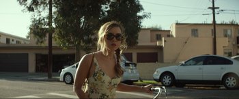 Movie still from “Ingrid Goes West” (2017), directed by Matt Spicer – A woman in a floral sundress riding a bicycle; Close Up shot, Over the shoulder angle
