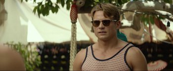 Movie still from “Ingrid Goes West” (2017), directed by Matt Spicer – A young man wearing sunglasses standing next to a tree; Close Up shot, Over the shoulder angle