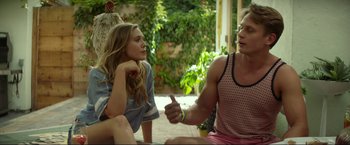 Movie still from “Ingrid Goes West” (2017), directed by Matt Spicer – A man and a woman sitting on the ground talking to each other; Medium shot, Over the shoulder angle