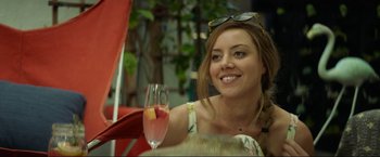 Movie still from “Ingrid Goes West” (2017), directed by Matt Spicer – A beautiful young lady sitting at a table with a glass of wine; Close Up shot, Over the shoulder angle
