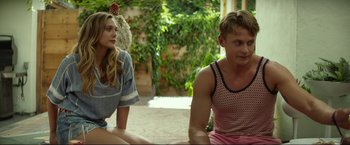 Movie still from “Ingrid Goes West” (2017), directed by Matt Spicer – A man and a woman sitting next to each other on the ground; Medium shot, Over the shoulder angle