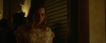 Movie still from “Ingrid Goes West” (2017), directed by Matt Spicer – A woman in a white dress standing next to a door; Medium shot, Over the shoulder angle