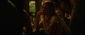 Movie still from “Ingrid Goes West” (2017), directed by Matt Spicer – A woman sitting at a table eating something off of a plate; Medium shot, Over the shoulder angle