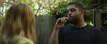 Movie still from “Ingrid Goes West” (2017), directed by Matt Spicer – A man and a woman sitting in front of each other outside; Medium shot, Low angle