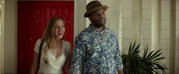 Movie still from “Ingrid Goes West” (2017), directed by Matt Spicer – A man and a woman standing next to each other in front of a red door; Medium shot, Over the shoulder angle