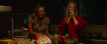 Movie still from “Ingrid Goes West” (2017), directed by Matt Spicer – Two women sitting at a dinner table drinking beverages; Medium shot, Low angle