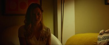 Movie still from “Ingrid Goes West” (2017), directed by Matt Spicer – A woman sitting in a chair in front of a yellow wall; Medium shot, Over the shoulder angle
